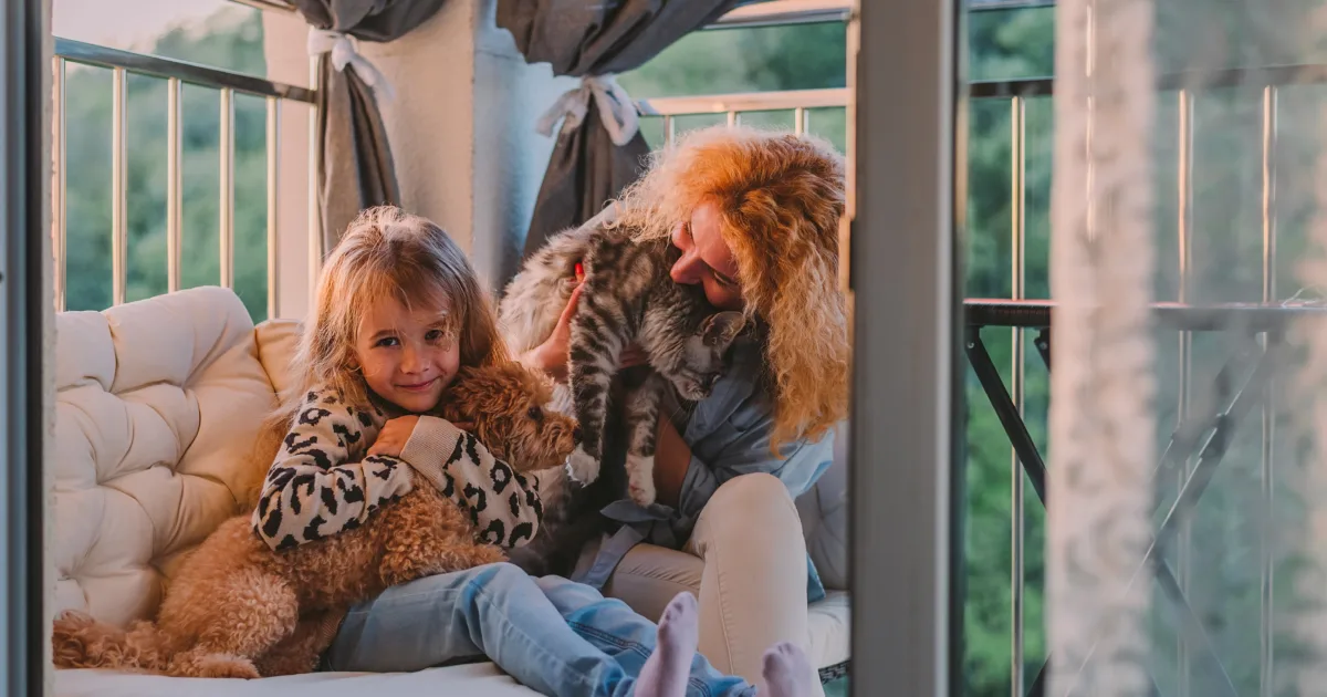 Little girl and her mom playing with a cavoodle