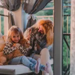 Little girl and her mom playing with a cavoodle