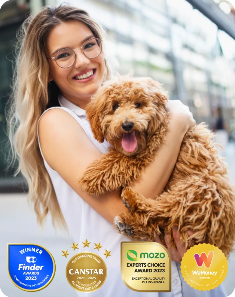 Female pet owner hugging and carrying her Labradoodle puppy