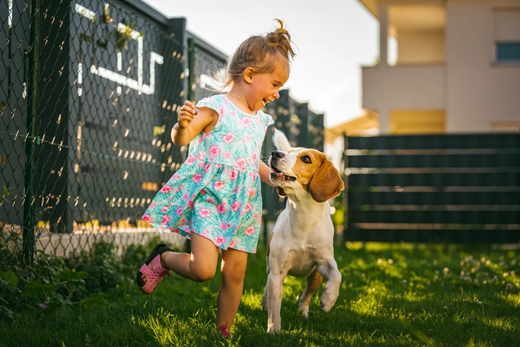 child running with her dog in the backyard